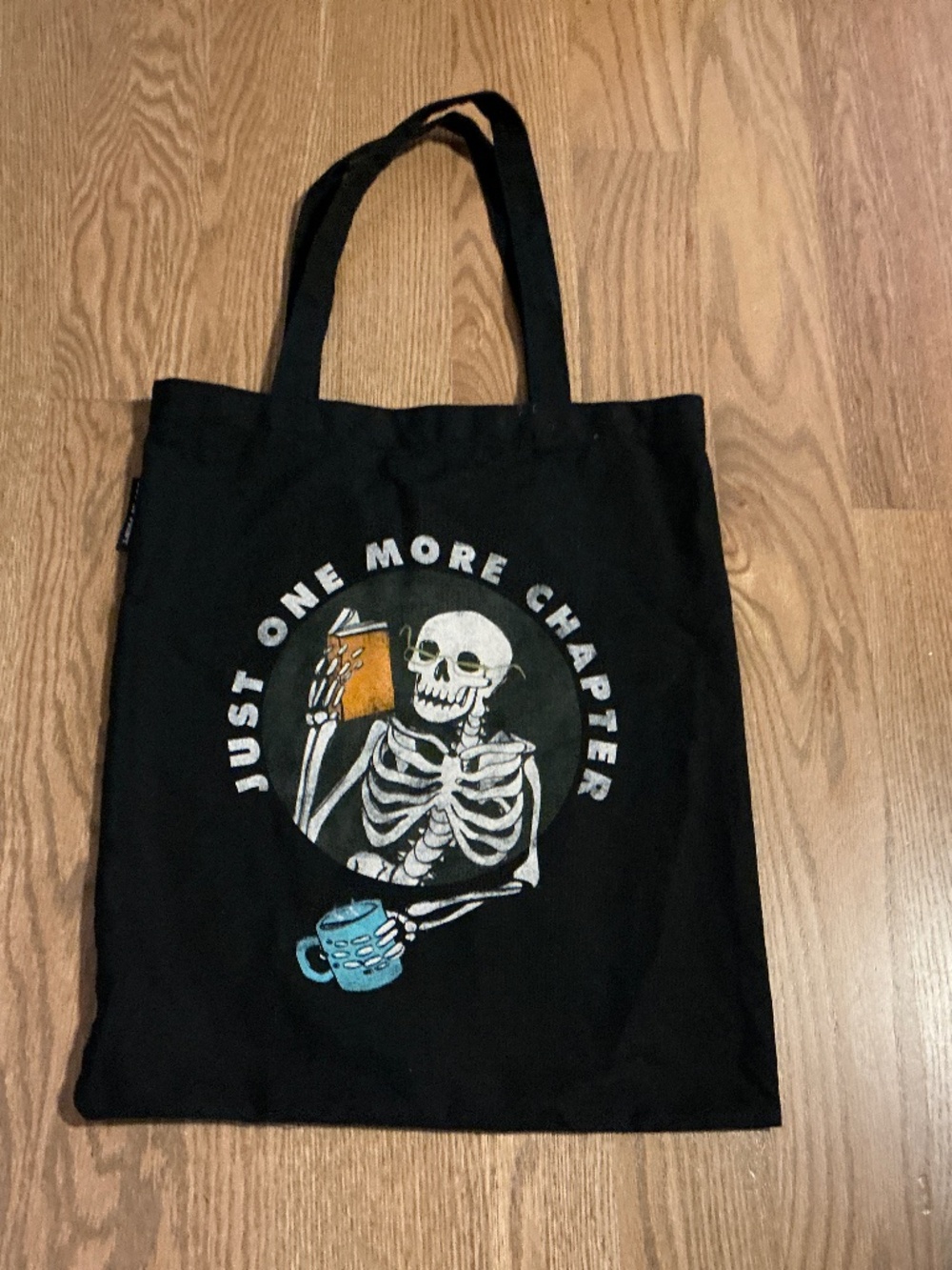 Black Canvas Tote JUST ONE MORE CHAPTER by Out of Print Skeleton reading